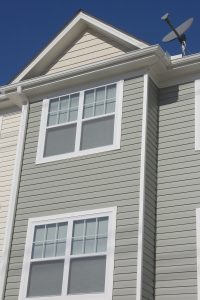 New vinyl windows in a two-story home with gray vinyl siding.