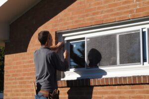 Picture of a technician installing a replacement window on a home.
