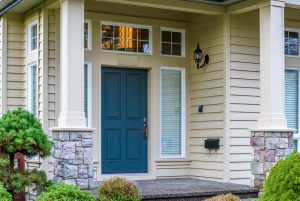 Home with vinyl siding and a blue front entry door.